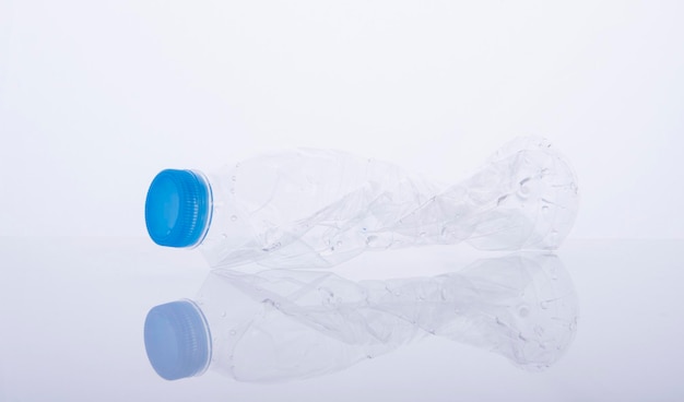Close-up van een verpletterde plastic fles tegen een grijze achtergrond