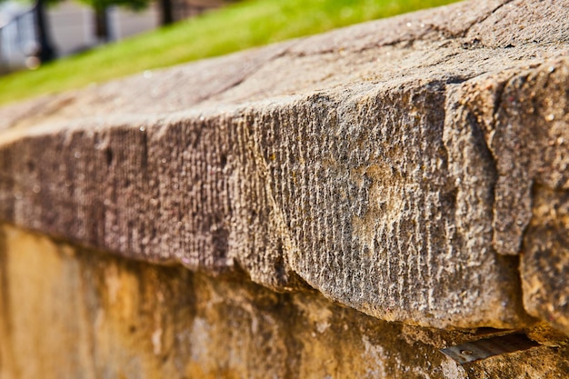 Close-up van een versleten betonnen muur met gras daarboven