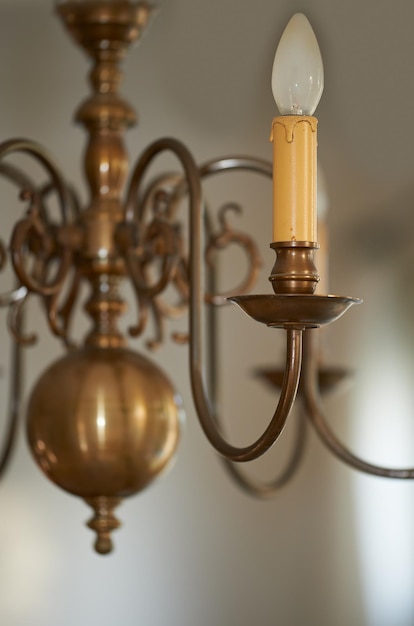 Close-up van een vintage koperen kroonluchter die als decoratie in een foyer inkomhal of eetkamer hangt tijdens een black-out Gouden kaars als verlichtingsdecor voor een interieur in koninklijke Victoriaanse stijl