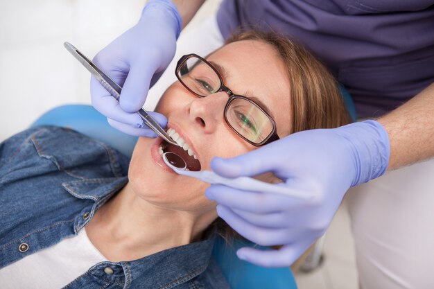 Close up van een volwassen vrouwelijke patiënt met tandheelkundige behandeling in de kliniek