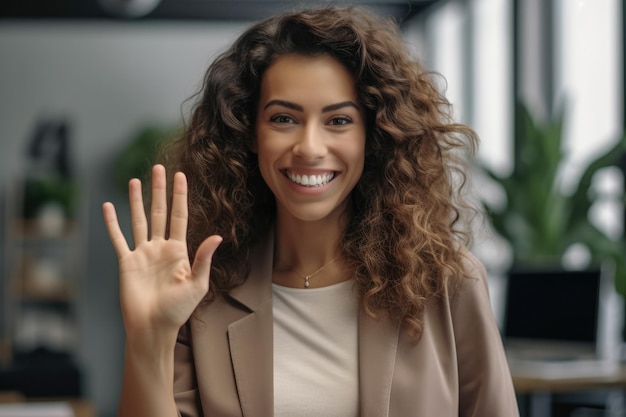 Close-up van een vrouw aan het werk die glimlacht op haar werkplek en een high five geeft aan de camera