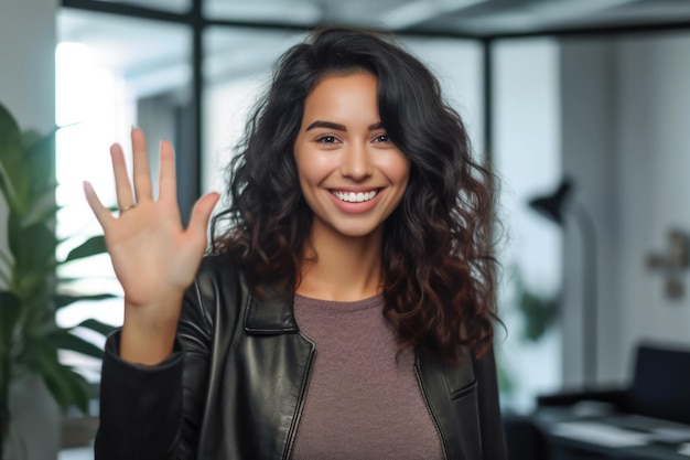 Close-up van een vrouw aan het werk die glimlacht op haar werkplek en een high five geeft aan de camera