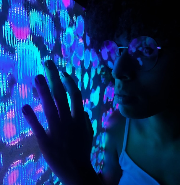 Close-up van een vrouw bij een verlichte muur