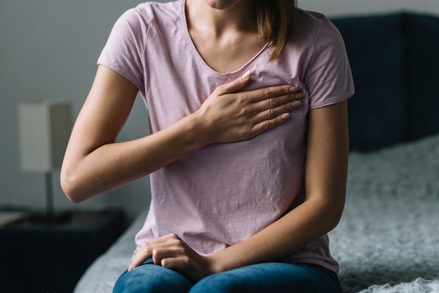 Close-up van een vrouw die aan borstpijn lijdt