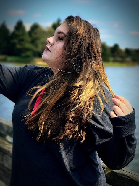 Foto close-up van een vrouw die bij het meer staat tegen de lucht