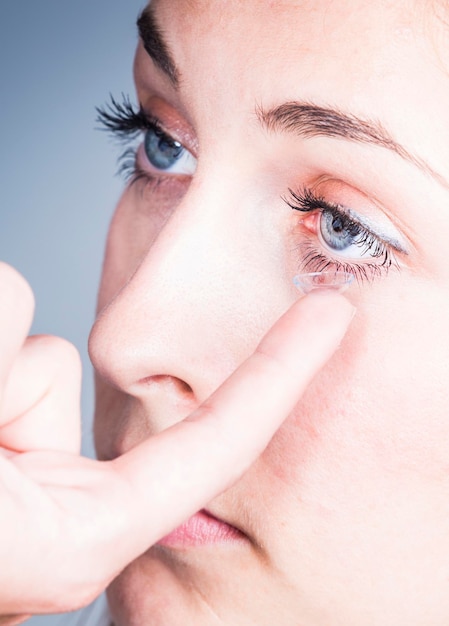 Close-up van een vrouw die contactlenzen aanbrengt
