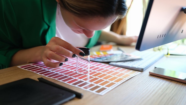 Close-up van een vrouw die de juiste kleur zoekt voor promotie en door een vergrootglas kijkt