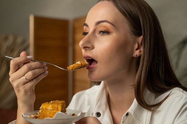 Foto close-up van een vrouw die een honingtaart eet