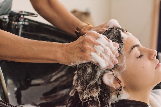 Close-up van een vrouw die haar haar wast in een schoonheidssalon door Kapsalon.