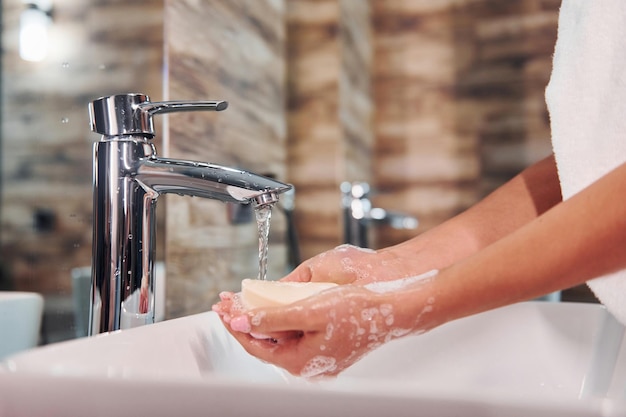 Close-up van een vrouw die in de badkamer staat en handen wast.