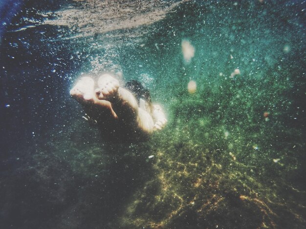 Foto close-up van een vrouw die onder water zwemt