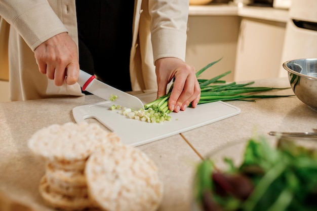 Close-up van een vrouw die plantaardige veganistische salade bereidt in de keuken Gezonde voeding en dieetconcept levensstijl Thuis koken