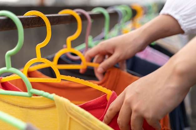 Close-up van een vrouw die schone, natte kleren aan een waslijn hangt in de droogtuin