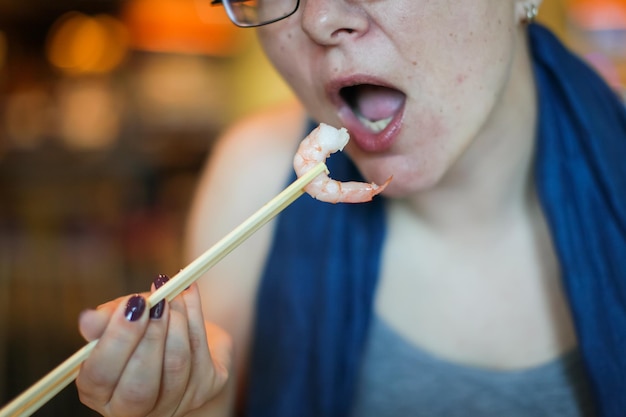 Foto close-up van een vrouw die thuis garnalen eet