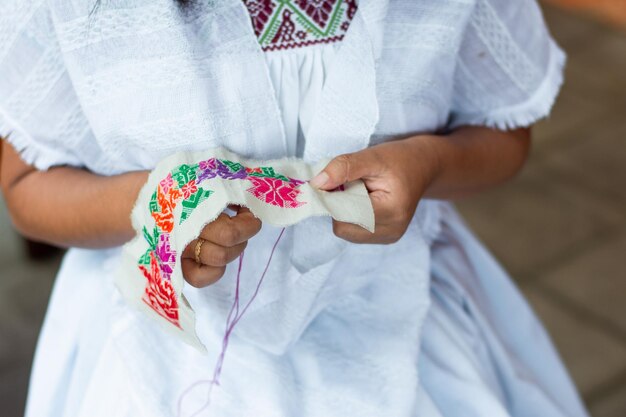 Close up van een vrouw die traditionele patronen borduurt