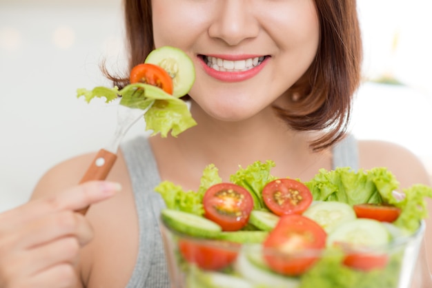 Close-up van een vrouw die verse salade eet