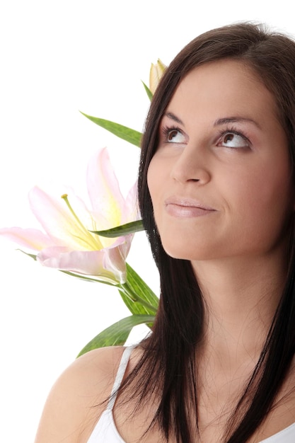 Foto close-up van een vrouw die wegkijkt door bloemen tegen een witte achtergrond