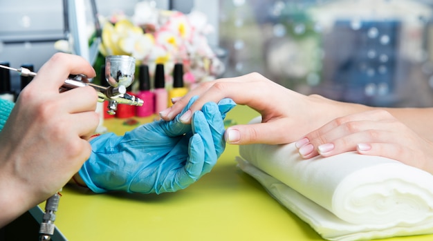 Close-up van een vrouw in een spijkersalon wordt geschoten die een manicure ontvangen die