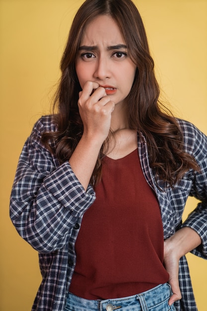 Close-up van een vrouw met een bezorgde uitdrukking die vinger bijt terwijl ze met copyspace staat