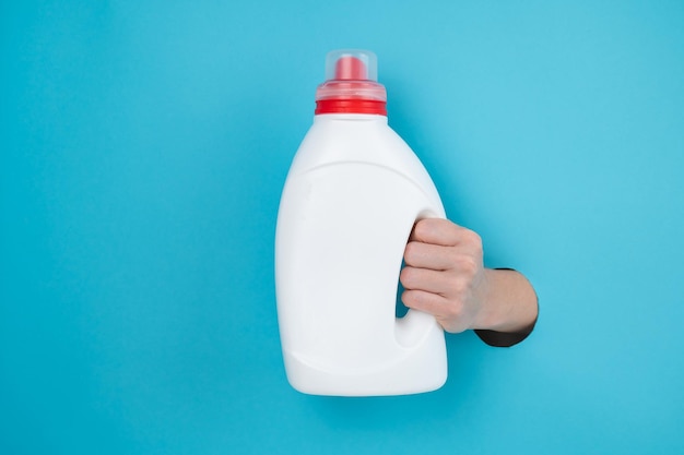 Close-up van een vrouw met een fles tegen een blauwe achtergrond
