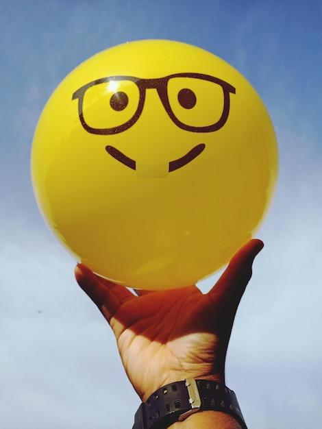 Foto close-up van een vrouw met een gele bal tegen de lucht