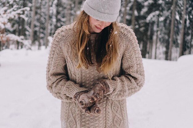 Close-up van een vrouw met een hoed tegen bomen tijdens de winter