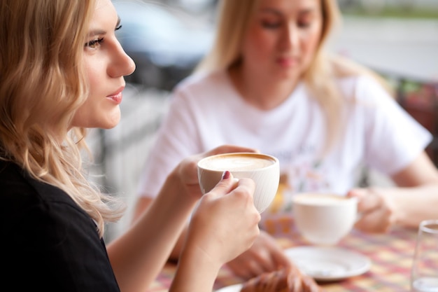 Close-up van een vrouw met een koffiekop in een café
