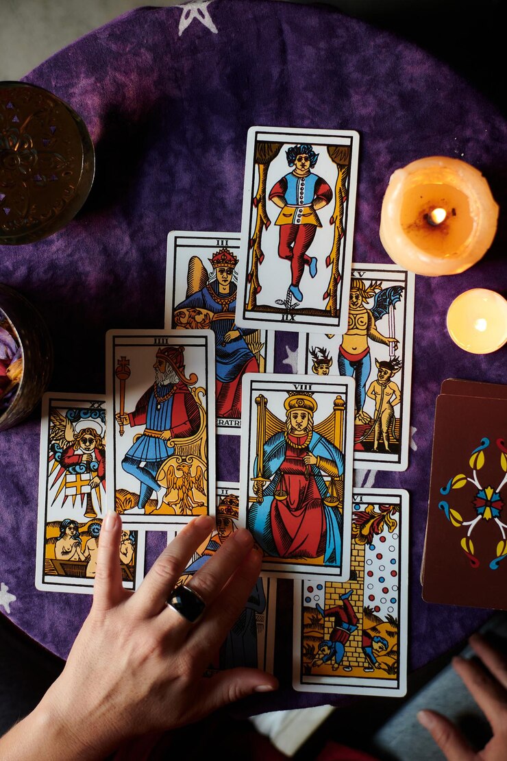 Close-up van een waarzegger die tarotkaarten leest op een tafel met paars tafelkleed