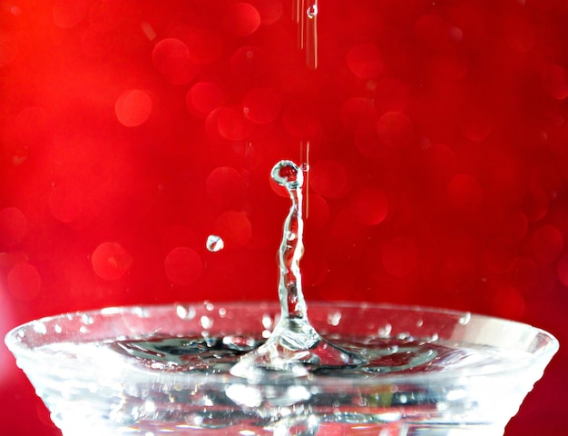 Close-up van een waterdruppel die in een glas valt.