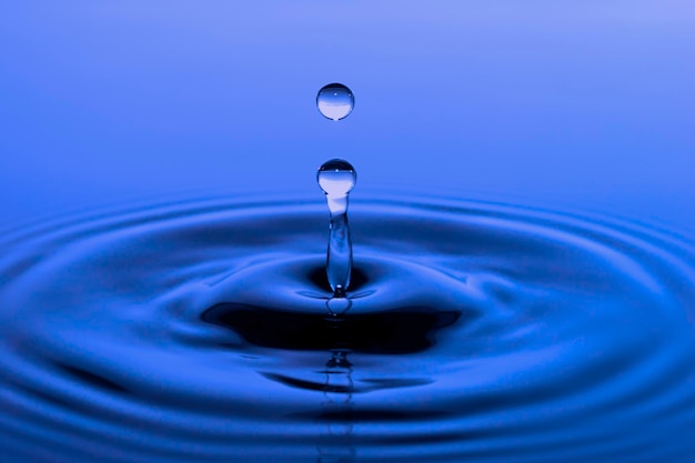 Close-up van een waterdruppel tegen een blauwe achtergrond