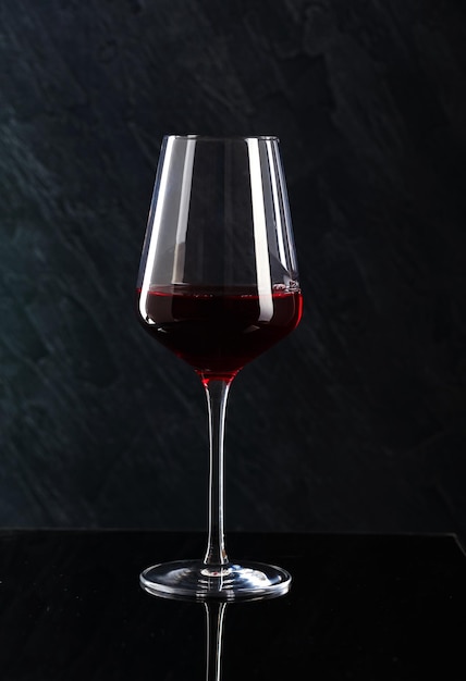 Close-up van een wijnglas op tafel tegen een zwarte achtergrond