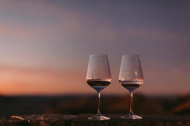 Close-up van een wijnglas tegen de hemel bij zonsondergang