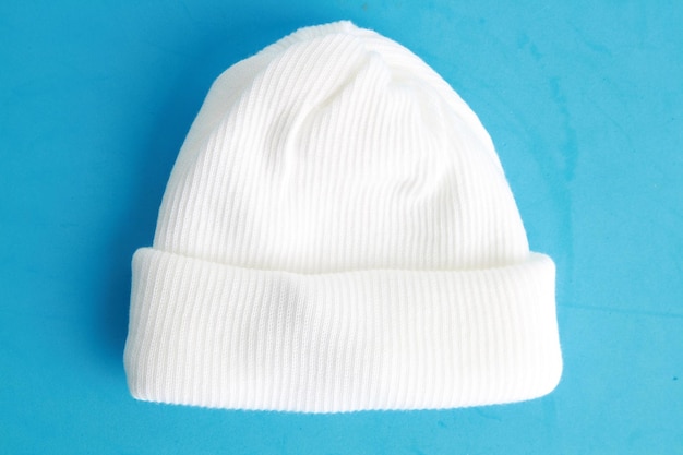 Close-up van een witte breihoed op blauwe achtergrond