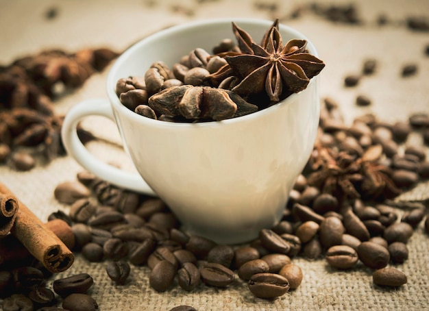 Close-up van een witte koffiekop met koffiebonen