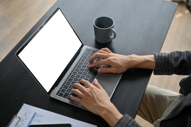 Close-up van een zakenman die aan zijn project werkt in de kantoorruimte met laptop