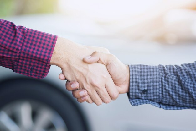 Close-up van een zakenman hand schudden investeerder tussen twee collega's OK, slagen in het bedrijfsleven Hand in hand.