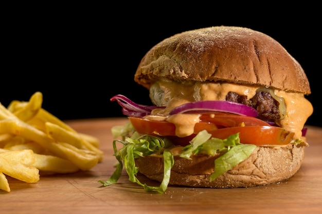 Close up van een zelfgemaakte hamburger met salade op een houten bord hakken