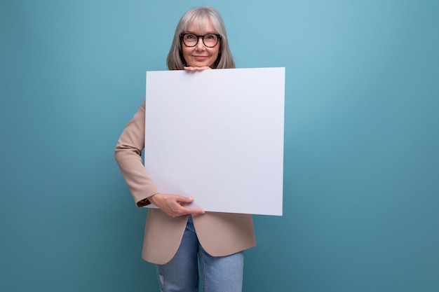 Close-up van een zelfverzekerde volwassen vrouw in een jasje met een mocap abstracte poster op een lichte achtergrond