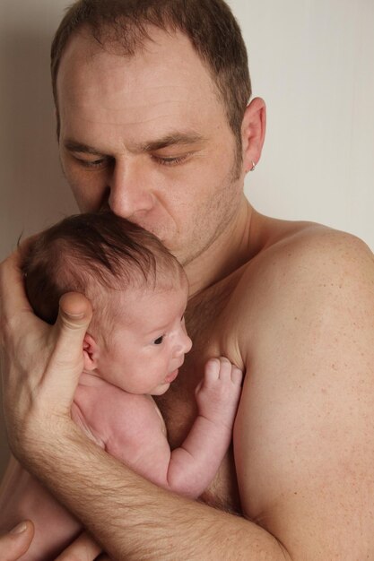 Close-up van een zorgzame vader met een baby in haar armen