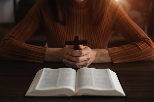 Foto close-up van eenvoudige houten christelijke kruishalsband op bijbelconcept hoop geloof christendom godsdienst