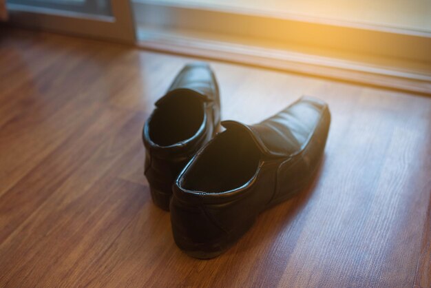 Foto close-up van formele schoenen op de hardhouten vloer thuis