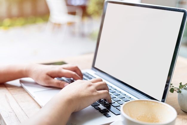 Close-up van freelance mensen business vrouwelijke casual werken met laptopcomputer met koffiekopje en smartphone in coffeeshop