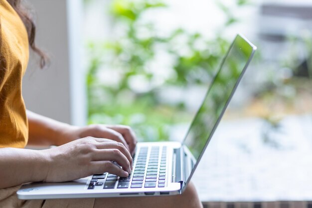 Close-up van freelance mensen zakelijke vrouwelijke casual werken met laptopcomputer met koffiekopje en smartphone in coffeeshop zoals de achtergrond, communicatieconcept