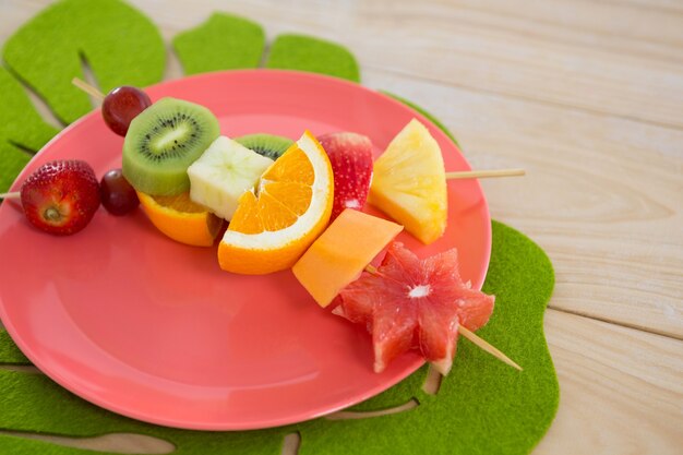 Close-up van fruitspiesjes in plaat op houten tafel