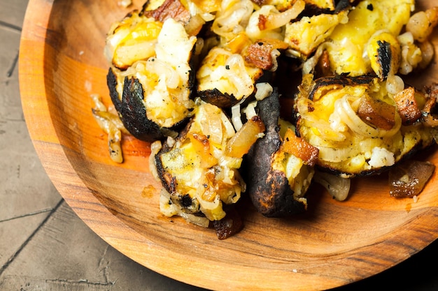 Close-up van gebakken aardappelen gekookt in het verbrande brandhout in de houten plaat