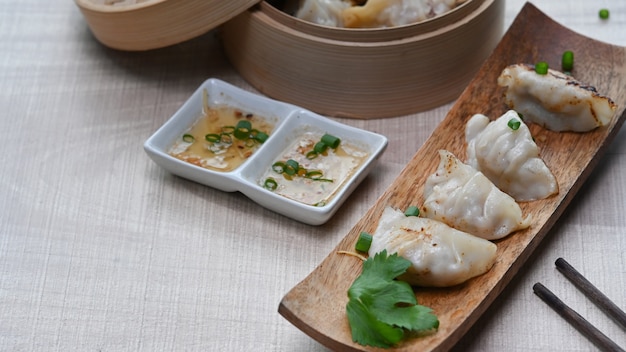 Close-up van gebakken gyozas in plaat en dumplings in bamboestoomboot
