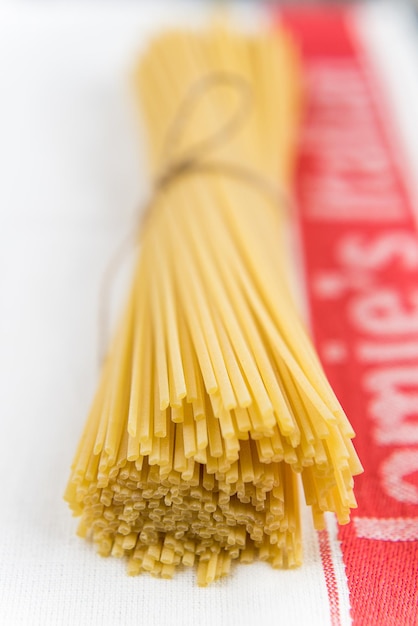 Close-up van gebonden rauwe spaghetti op stof