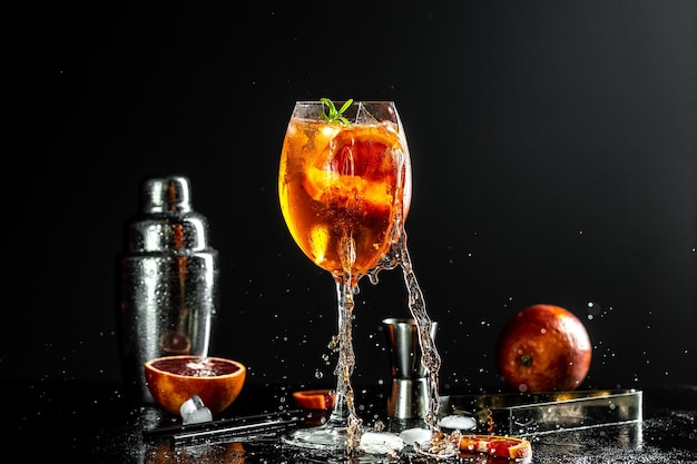 Close up van gebroken Aperol spritz cocktail in groot wijnglas op zwarte achtergrond voor eten en drinken ontwerp met water Splash het concept van gevaar