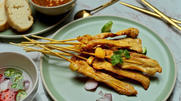 Close-up van gegrilde varkenssaté (Moo Satay) geserveerd met pindasaus