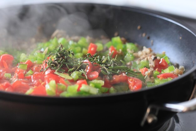 Foto close-up van gehakte groenten in de pan